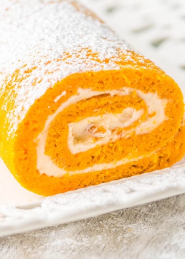 Pumpkin Roll - With my EASY pumpkin roll recipe and clear specific directions,  you're going to be a pumpkin roll pro! No dish towel required to roll up my classic pumpkin roll cake that's full of rich pumpkin spice flavor and tangy cream cheese frosting! A fall favorite that all pumpkin fans will just ADORE! Freezes well and makes a great hostess gift! 