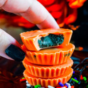 A stack of white chocolate peanut butter cups with a hand grabbing the top piece.