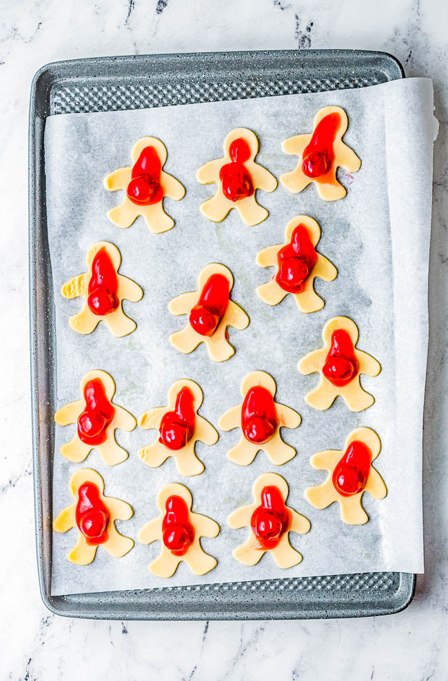 Mummy Hand Pies - A FUN and EASY Halloween treat that kids and adults alike both love! Buttery flakey pie crust with tangy-sweet cherry pie filling give great flavor to these festive and whimsical little goodies! Use store bought pie crust to save time and they're ready in 45 minutes. These little mummies will be the hit of your Halloween party!