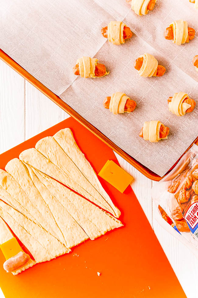Cheddar Pigs In A Blanket - Sliced cheddar cheese and flaked salt takes this classic game day recipe and turns up the flavor! A FAST and EASY appetizer for holiday parties, get-togethers, or events! Along with the easy whisk-together dipping sauce, I promise you there won't be any left over!