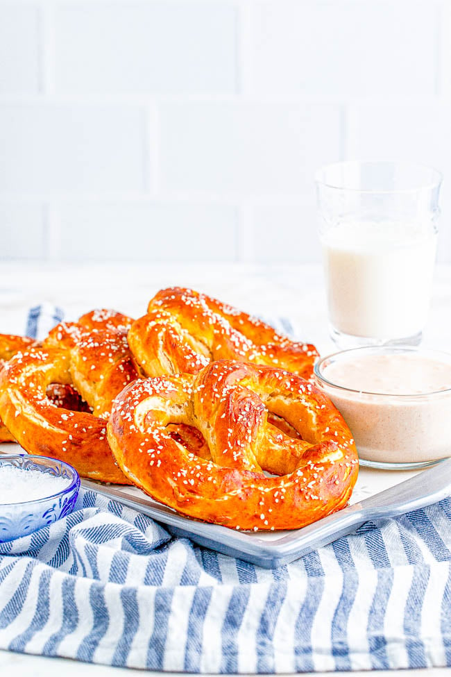 Homemade Soft Pretzels - These jumbo pretzels are soft, chewy, and just like the IRRESISTIBLE ones at your local mall's food court! Skip the mall and make these at home in ONE HOUR with this EASY to follow recipe and step-by-step photos! Whether you want to sprinkle them with coarse salt or cinnamon-sugar, these carby delights will be an automatic family FAVORITE! 