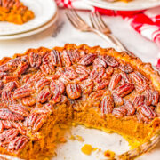 A pumpkin pecan pie with a slice missing.