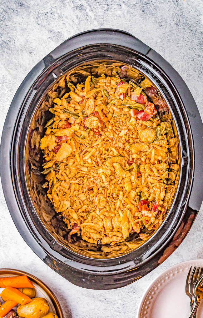 Slow Cooker Cheesy Green Bean Casserole - Fresh green beans are cooked with bacon and a THREE CHEESE sauce in the slow cooker to free up valuable oven space!  NO CANNED SOUP nor processed sauces here. An EASY comfort food side dish that's perfect for Thanksgiving, Christmas, parties, and events!