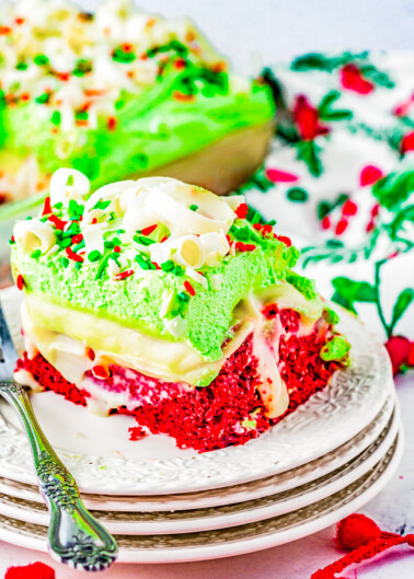 Christmas Red Velvet Poke Cake - The EASIEST and most impressive Christmas cake! You'll have your friends and family thinking you're a rock star pastry chef! Moist red velvet cake is infused with white chocolate pudding, topped with whipped topping, sprinkles, and white chocolate curls! Ready in ONE HOUR and uses shortcut ingredients to make your job as easy and hassle-free as possible! 