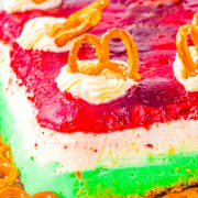 Layered Cranberry Jello Salad - A festive holiday layered recipe with cranberries, pineapple, cream cheese, pecans, and pretzels! A little bit creamy, crunchy, sweet, and a little salty. A nostalgic family favorite with an impressive presentation to wow your holiday guests!