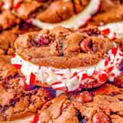 Double Chocolate Peppermint Sandwich Cookies - Rich, decadent, soft and chewy double chocolate cookies are sandwiched together with a tangy cream cheese filling. Rolled in crushed candy canes and drizzled with white chocolate for extra flavor and holiday festiveness! They're the PERFECT Christmas cookie! 