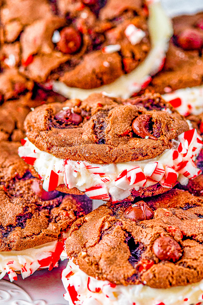 Double Chocolate Peppermint Sandwich Cookies - Rich, decadent, soft and chewy double chocolate cookies are sandwiched together with a tangy cream cheese filling. Rolled in crushed candy canes and drizzled with white chocolate for extra flavor and holiday festiveness! They're the PERFECT Christmas cookie! 