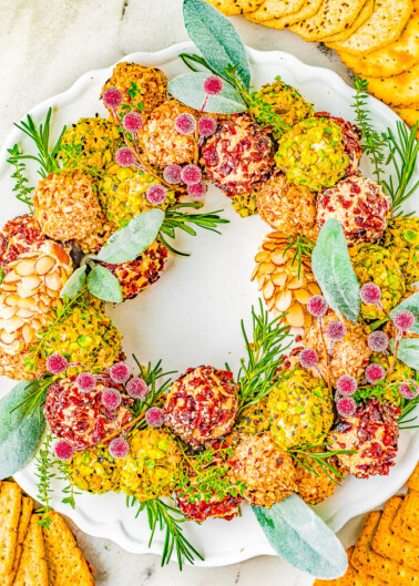Cheese Ball Wreath - A delectable cheese ball mixture rolled in festive and colorful toppings and arranged into a wreath! A show-stopping presentation of wonderful cheese bites for your holiday parties and entertaining tables! EASY to make and can be made IN ADVANCE! No one can resist the allure of cheese!