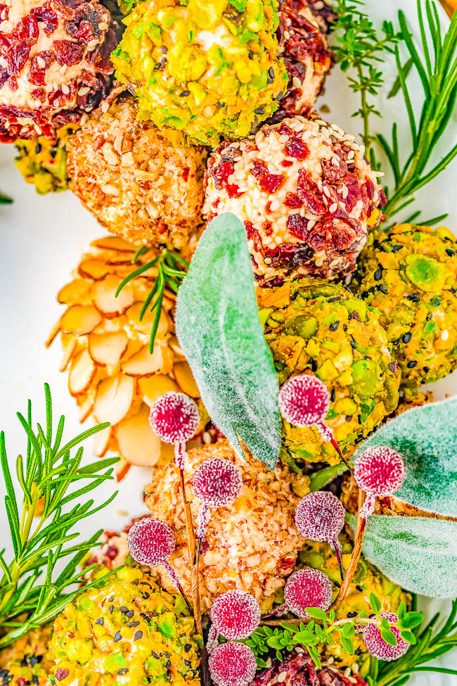 Cheese Ball Wreath - A delectable cheese ball mixture rolled in festive and colorful toppings and arranged into a wreath! A show-stopping presentation of wonderful cheese bites for your holiday parties and entertaining tables! EASY to make and can be made IN ADVANCE! No one can resist the allure of cheese!