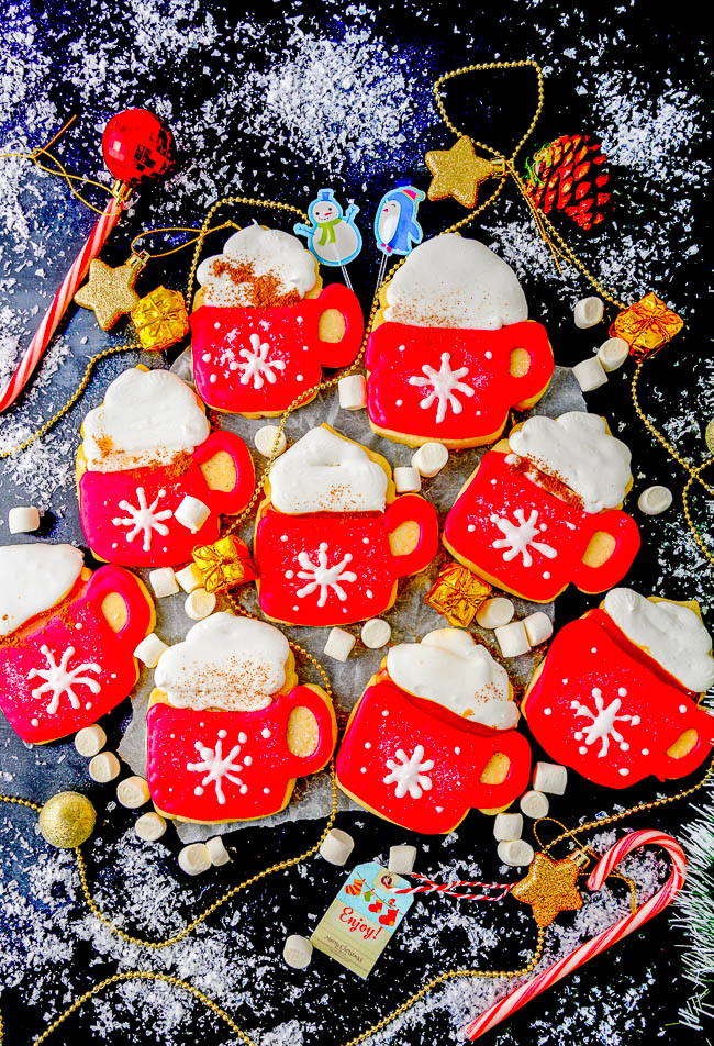Cut-Out Coffee Cup Cookies - Soft, buttery sugar cookies cut out in the shape of coffee cups and decorated with red and white royal icing! These sugar cookies are PERFECT for Christmas as well as for wintertime parties and entertaining. No one will be able to resist these unique beauties!