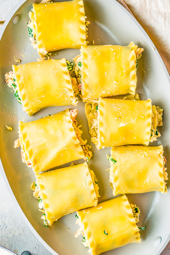 White Chicken Lasagna Roll Ups - Chicken and bacon combined with spinach and herbs, rolled up in lasagna noodles, and smothered in a homemade three-cheese alfredo sauce! This is the ultimate CREAMY CHEESY COMFORT food recipe that everyone ADORES! Can be prepped in advance and baked off later.