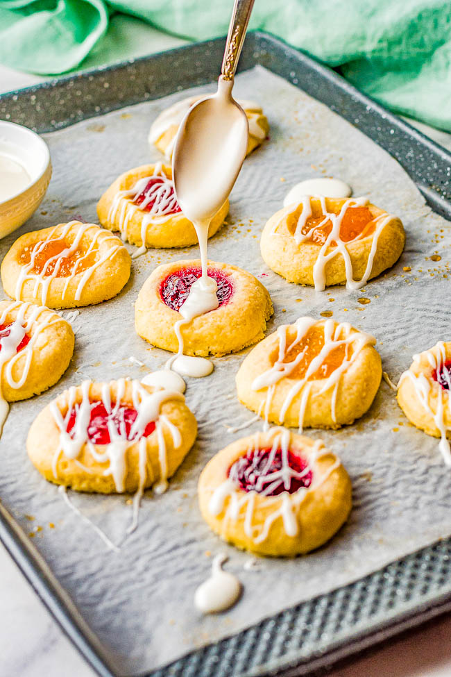 Classic Jam Thumbprint Cookies — These easy thumbprint cookies are tender, buttery, and the 3 different types of jam turns into chewy little jewels that make these nostalgic family favorite cookies! Great for holiday entertaining, cookie exchanges, showers, or just because! No one can resist the allure of these classic thumbprint cookies!