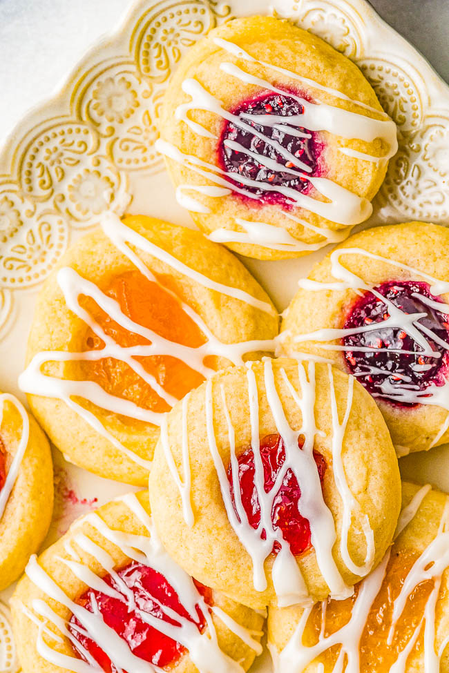 Classic Jam Thumbprint Cookies — These easy thumbprint cookies are tender, buttery, and the 3 different types of jam turns into chewy little jewels that make these nostalgic family favorite cookies! Great for holiday entertaining, cookie exchanges, showers, or just because! No one can resist the allure of these classic thumbprint cookies!