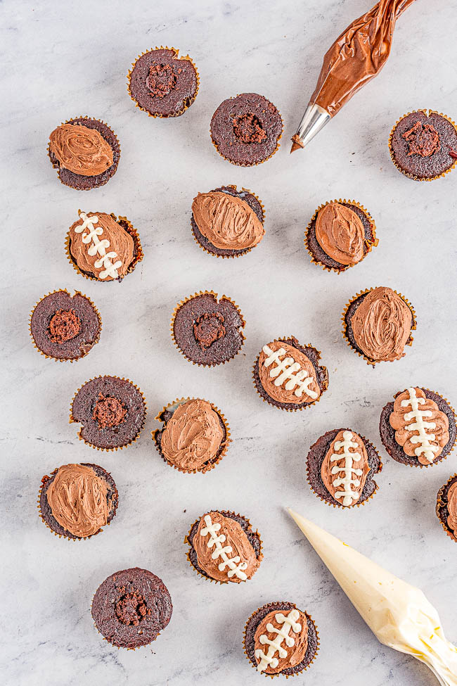 Chocolate Football Cupcakes - Decadent chocolate cupcakes, filled with smooth rich chocolate ganache, and topped with creamy chocolate buttercream frosting for a trifecta of chocolate! The cupcakes will be game day winners with all your hungry fans!