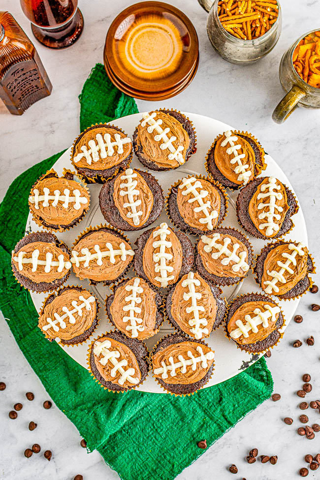 Chocolate Football Cupcakes - Decadent chocolate cupcakes, filled with smooth rich chocolate ganache, and topped with creamy chocolate buttercream frosting for a trifecta of chocolate! The cupcakes will be game day winners with all your hungry fans!