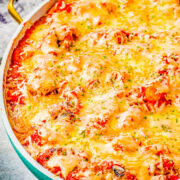 A dish of cheesy gnocchi with meatballs.