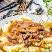 A plate of mashed potatoes topped with Instant Pot beef tips.
