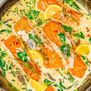 Salmon Florentine - You don't need to go to Florence, Italy to enjoy this FAST and EASY Italian-inspired salmon recipe at home! Tender flaky salmon is bathed in a decadent cream sauce made with heavy cream, wine, Parmesan cheese, and more! Fresh spinach and mushrooms add extra texture and flavor to this super flavorful fish dish!