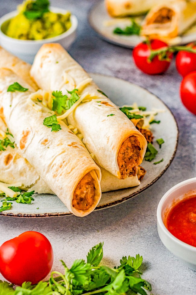 Baked Cheesy Beef Taquitos - Craving Mexican food? Make these EASY taquitos made with seasoned ground beef, melted cheese, cream cheese, sour cream, salsa, and baked to crispy perfection! Family friendly, picky-eater approved, and PERFECT for busy weeknight dinners, game day events or parties! 