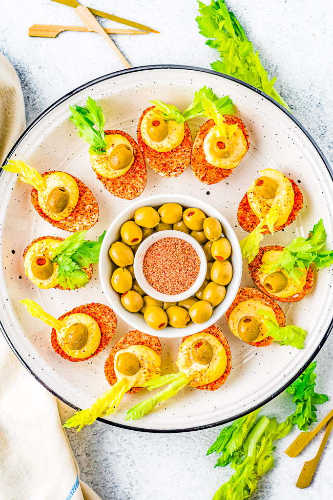 Bloody Mary Deviled Eggs - All the flavors of a bloody Mary in deviled egg form! There's Old Bay, lemon juice, hot sauce, Dijon mustard, celery salt, horseradish, pimento-stuffed green olives, and celery! Super TASTY and FUN for events, parties, and holiday get-togethers! 