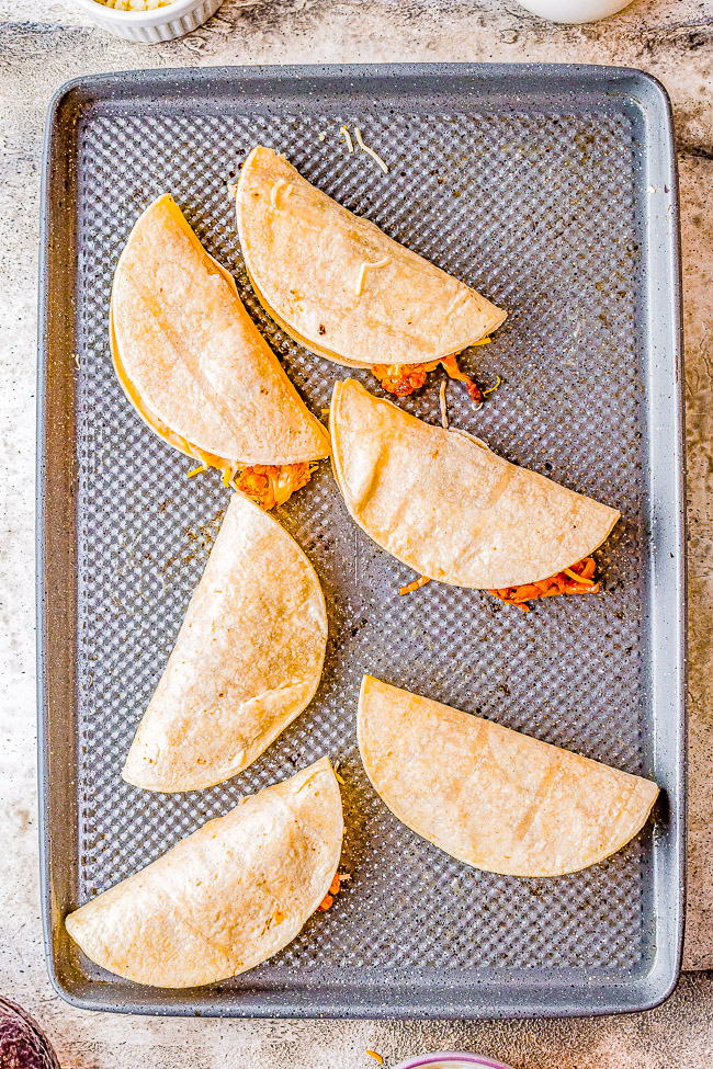 Cauliflower Tinga Tacos with Avocado Crema - Roasted cauliflower is drenched in a smoky, perfectly spicy chipotle sauce, then folded into corn tortillas, cheese is added, and baked to crispy perfection! A bright avocado crema sauce is the finishing touch! Naturally gluten-free vegetarian food never tasted so AMAZING! You'll never miss the meat in these healthy tacos!