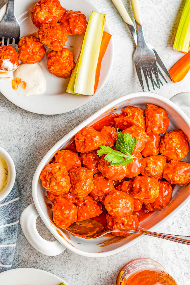 Slow Cooker Buffalo Chicken Meatballs - EASY homemade chicken meatballs that simmer in buffalo wing sauce, seasonings, and spices in your slow cooker! Juicy and full of all the flavor of traditional buffalo chicken wings, minus the messy factor! Great for game day parties, holidays, graduations, or anytime you need an appetizer that kids and adults alike just adore! 