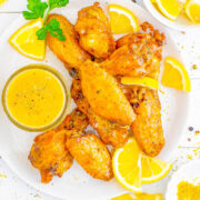 Baked Lemon Pepper Wings on a plate with sauce on the side.