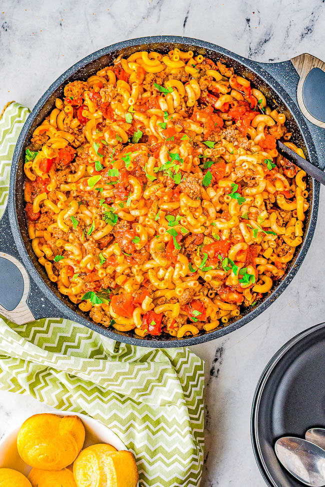 American Goulash - Hearty, easy, comfort food made with ground beef and sausage, tender elbow macaroni, green peppers, onions, and tomatoes. The mixture simmers in marinara sauce for layers of flavor! Ready in just 30 minutes and makes a big batch that's perfect for potlucks, picnics, game days, or to have planned leftovers on hand. This classic American goulash recipe is always a family favorite! 