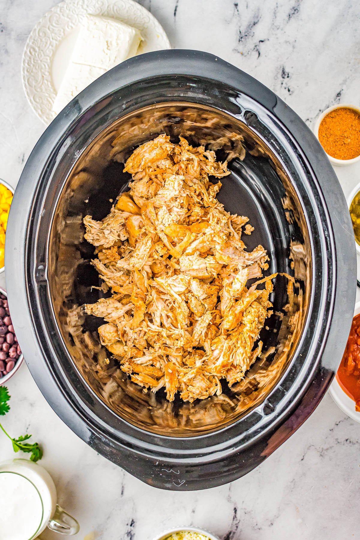 Slow Cooker Fiesta Chicken - An EASY Crock-Pot recipe for fiesta ranch chicken that the whole family LOVES! There's tender chicken, cream cheese, salsa, black beans, green chiles, and more which creates a little fiesta in your mouth! Serve it as-is, over rice, or in tacos. Perfect for busy weeknight dinners or make it for your next game day party! 