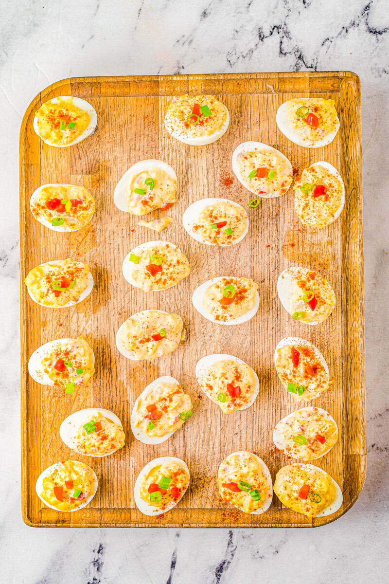 Pimento Cheese Deviled Eggs on a wooden cutting board.