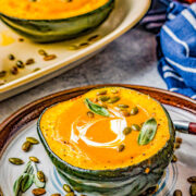 Two butternut squash soup halves full of roasted butternut squash soup.