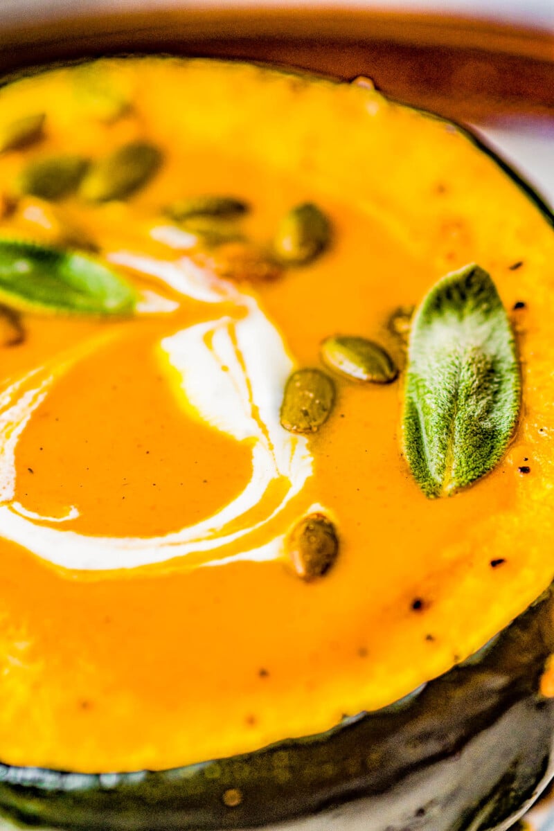 Butternut Squash Soup - Made with roasted butternut and acorn squash, sweet potatoes, carrots, sage, thyme, and more to create a gorgeous, creamy, fall-inspired soup that everyone LOVES! Great as a healthy main dish or a perfect side dish for Thanksgiving or the holidays! Serve it in acorn squash bowls for an even more festive look! 
