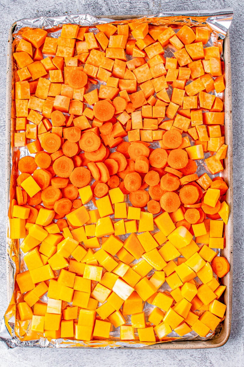 Butternut Squash Soup - Made with roasted butternut and acorn squash, sweet potatoes, carrots, sage, thyme, and more to create a gorgeous, creamy, fall-inspired soup that everyone LOVES! Great as a healthy main dish or a perfect side dish for Thanksgiving or the holidays! Serve it in acorn squash bowls for an even more festive look! 