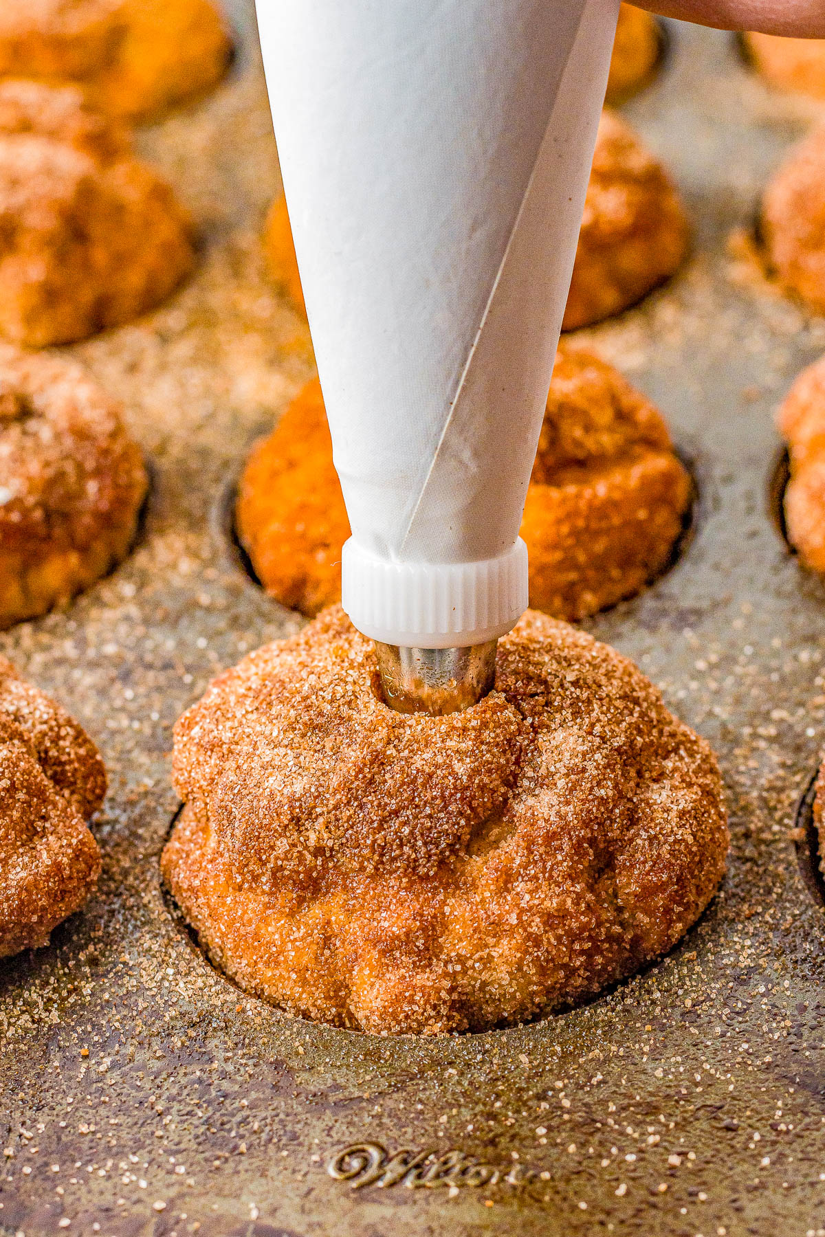 Dulce de Leche Churro Muffins - All the flavors and satisfaction of fresh churros but in muffin form with no frying involved! Brushed with melted butter, rolled in cinnamon-and-sugar, and filled with dulce de leche or caramel sauce, these FAST and EASY muffins are so soft, moist, and PERFECTLY decadent! 