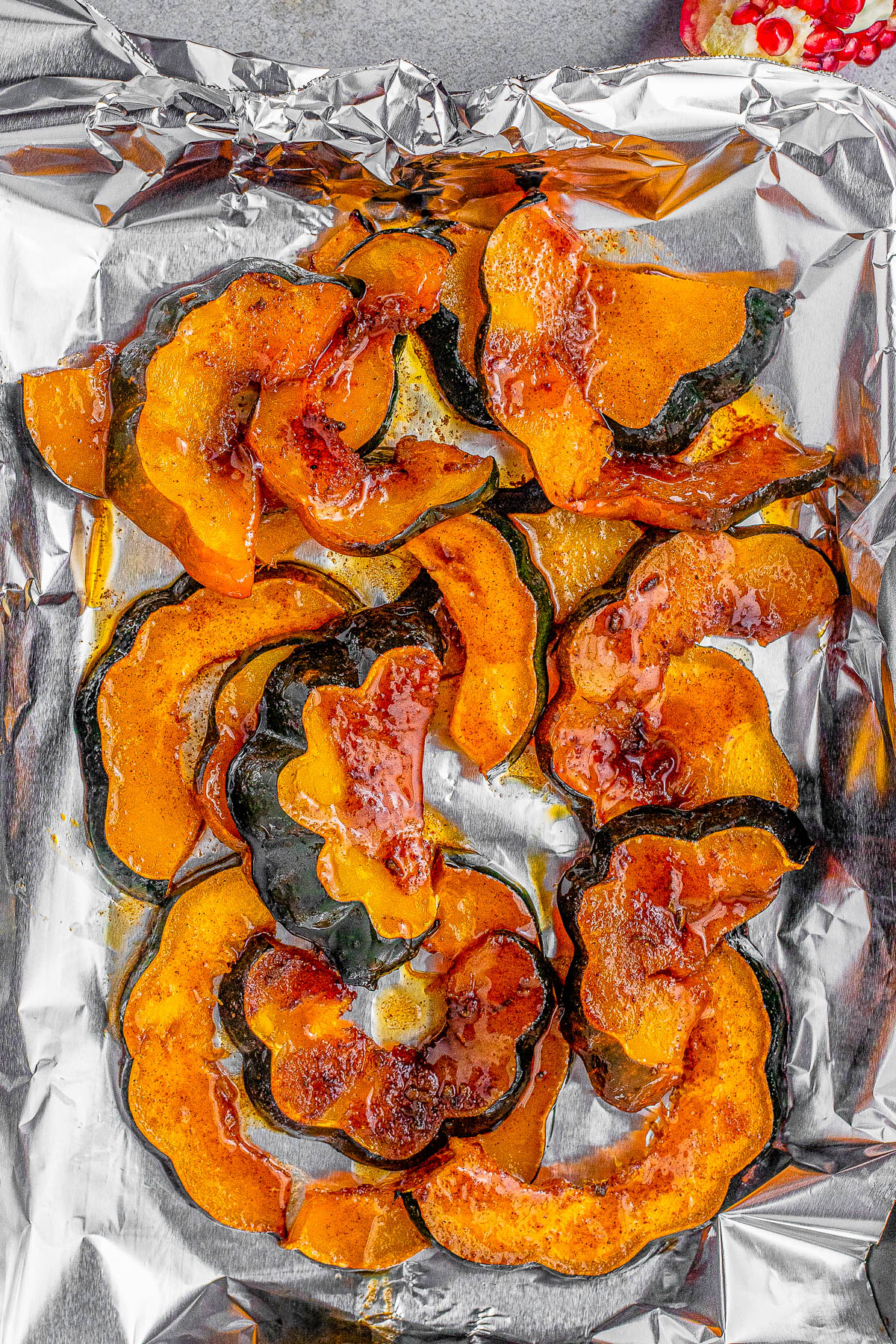 Sweet and Spicy Acorn Squash - Tender oven-roasted acorn squash is made extra fabulous with a sweet and spicy orange-infused butter sauce. It's topped with toasted sage leaves, pumpkin seeds, pomegranate arils, and a touch of orange zest for a festive touch. An EASY fall-flavored side dish that's ready in 20 minutes! Perfect for weeknight dinners or put it on your Thanksgiving or Christmas menus! 