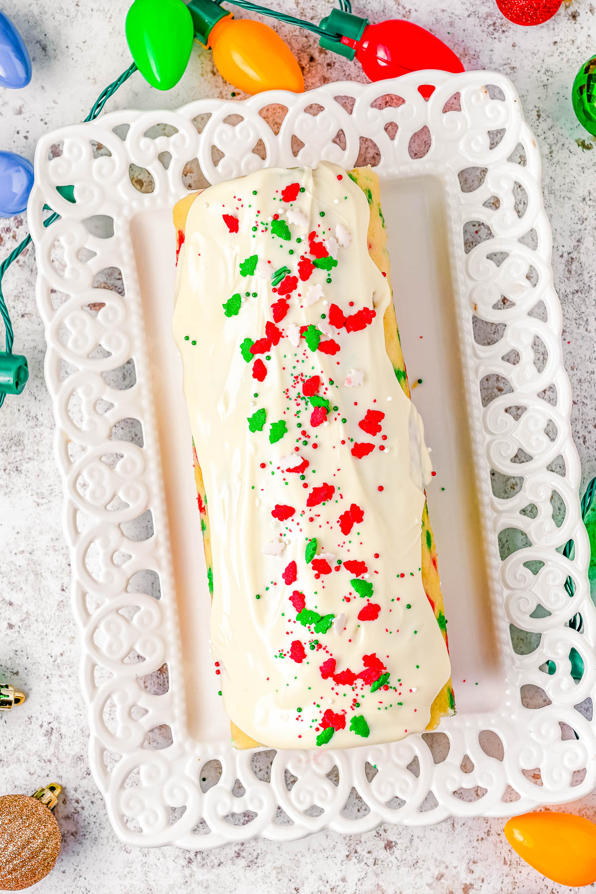 Christmas Cake Roll - Celebrate the holiday season with this scrumptious vanilla cake that's filled to the brim with a tangy-sweet cream cheese filling and topped with melted white chocolate! Plenty of red and green sprinkles add the PERFECT festive flair to this stunning holiday dessert recipe that's perfect for all your holiday entertaining needs and parties! Easy enough for novice bakers!