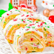 Christmas Cake Roll - Celebrate the holiday season with this scrumptious vanilla cake that's filled to the brim with a tangy-sweet cream cheese filling and topped with melted white chocolate! Plenty of red and green sprinkles add the PERFECT festive flair to this stunning holiday dessert recipe that's perfect for all your holiday entertaining needs and parties! Easy enough for novice bakers!