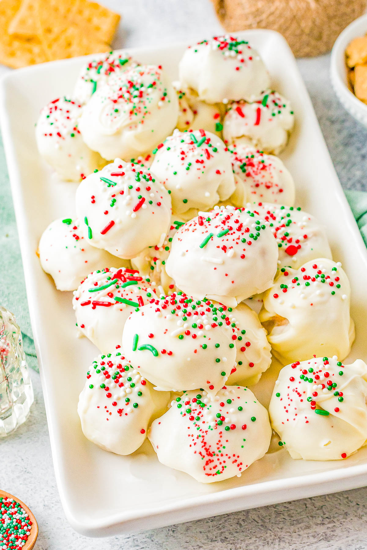 White Chocolate Peanut Butter Truffles - Fast, EASY, no-bake, and the BEST peanut butter truffles! A creamy peanut butter filling with a bit of texture from graham cracker crumbs, dipped in white chocolate (or milk or dark), and topped with sprinkles! Great MAKE-AHEAD homemade hostess gifts, for cookie exchanges, or set them out at Christmas parties.