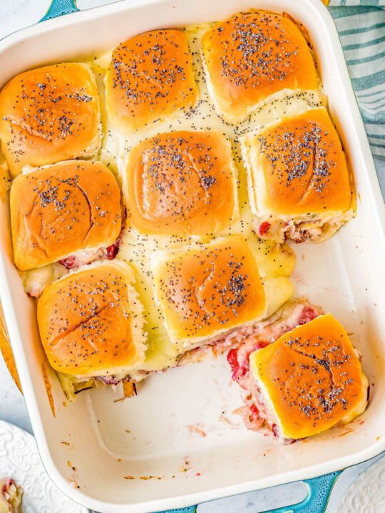 Turkey and Cheese Sliders - Juicy turkey, Swiss cheese, and cranberry sauce all nestled in soft Hawaiian rolls that are brushed with butter and topped with poppy seeds for the BEST turkey sliders! FAST, EASY, and takes advantage of leftover turkey! Deli turkey also works.