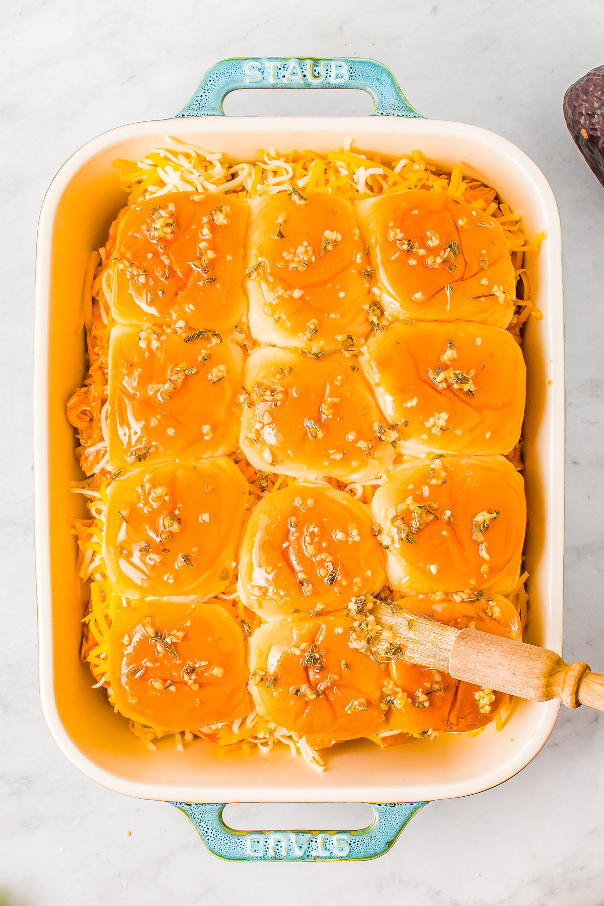 Chicken Enchilada Sliders - Juicy shredded chicken is tossed in spicy enchilada sauce and is layered in soft Hawaiian rolls along with plenty of melted cheese! Brush them with a melted garlic butter and oregano mixture and garnish with cilantro and avocado! PERFECT for entertaining, game days, Superbowl, or a FAST and EASY weeknight dinner that's ready in 30 minutes!