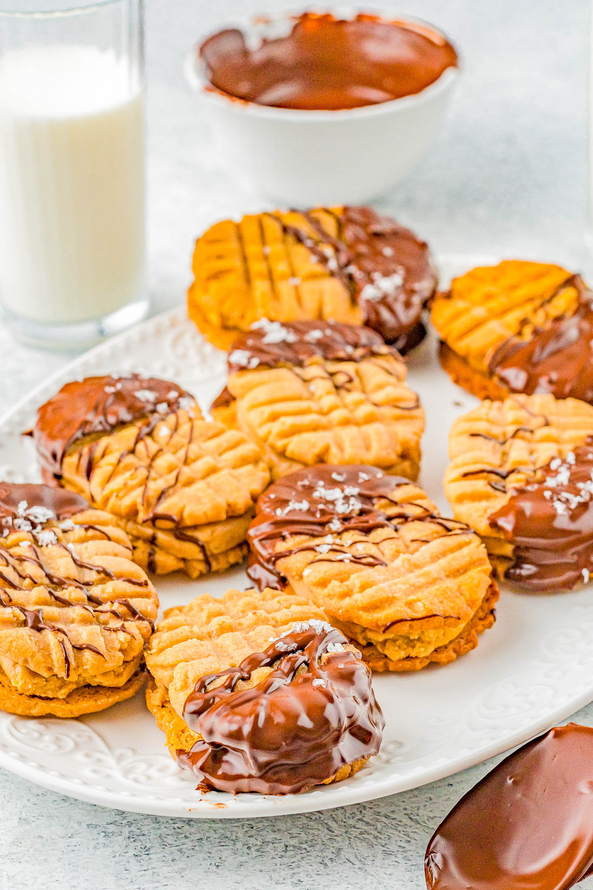 Homemade Nutter Butter Cookies - Homemade copycat Nutter Butters are so much better than the store bought originals! Creamy peanut butter filling is sandwiched between lightly crunchy peanut butter cookies. Pinches of optional sea salt and melted chocolate drizzled over the tops make these cookies simply THE BEST! 