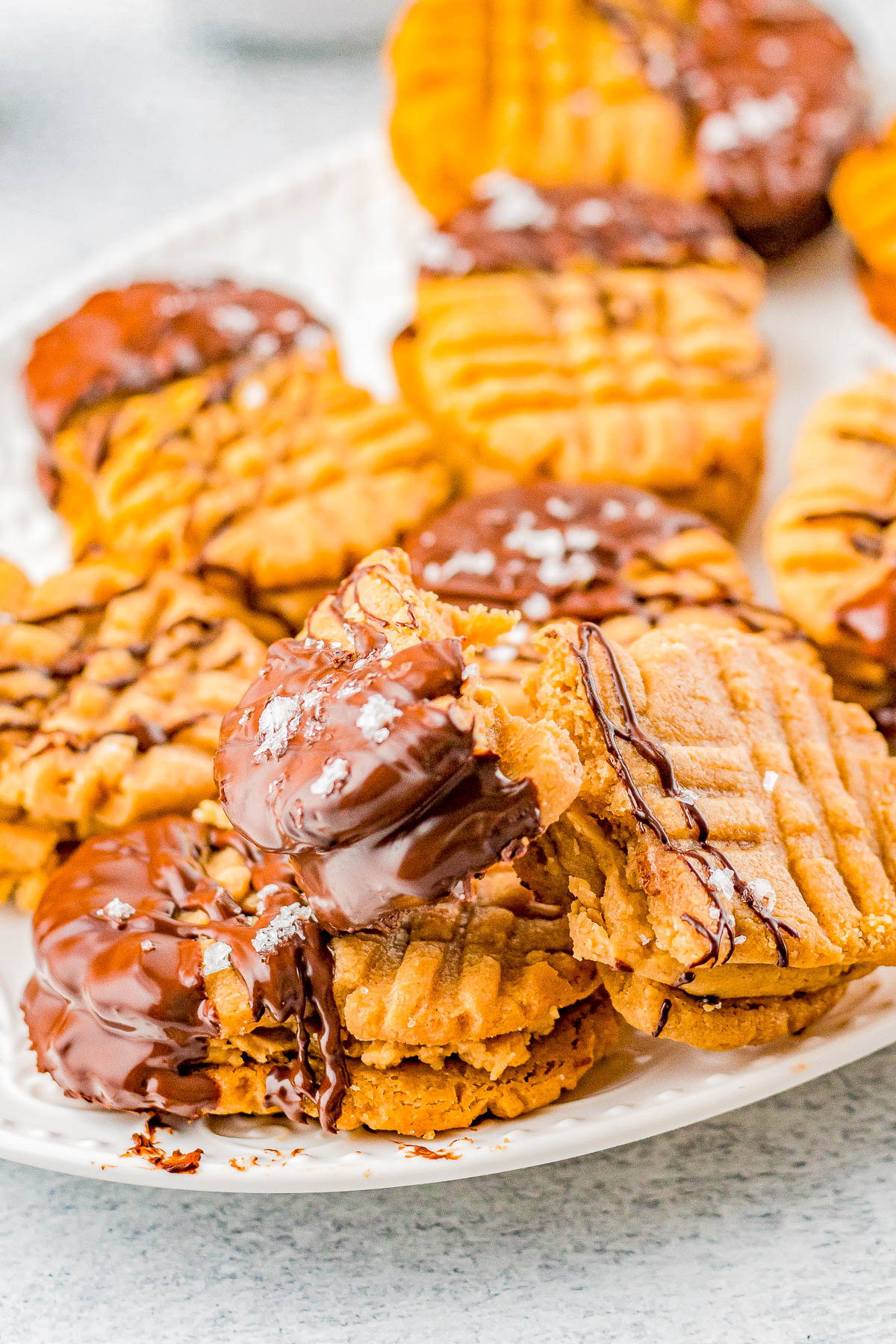 Homemade Nutter Butter Cookies - Homemade copycat Nutter Butters are so much better than the store bought originals! Creamy peanut butter filling is sandwiched between lightly crunchy peanut butter cookies. Pinches of optional sea salt and melted chocolate drizzled over the tops make these cookies simply THE BEST! 