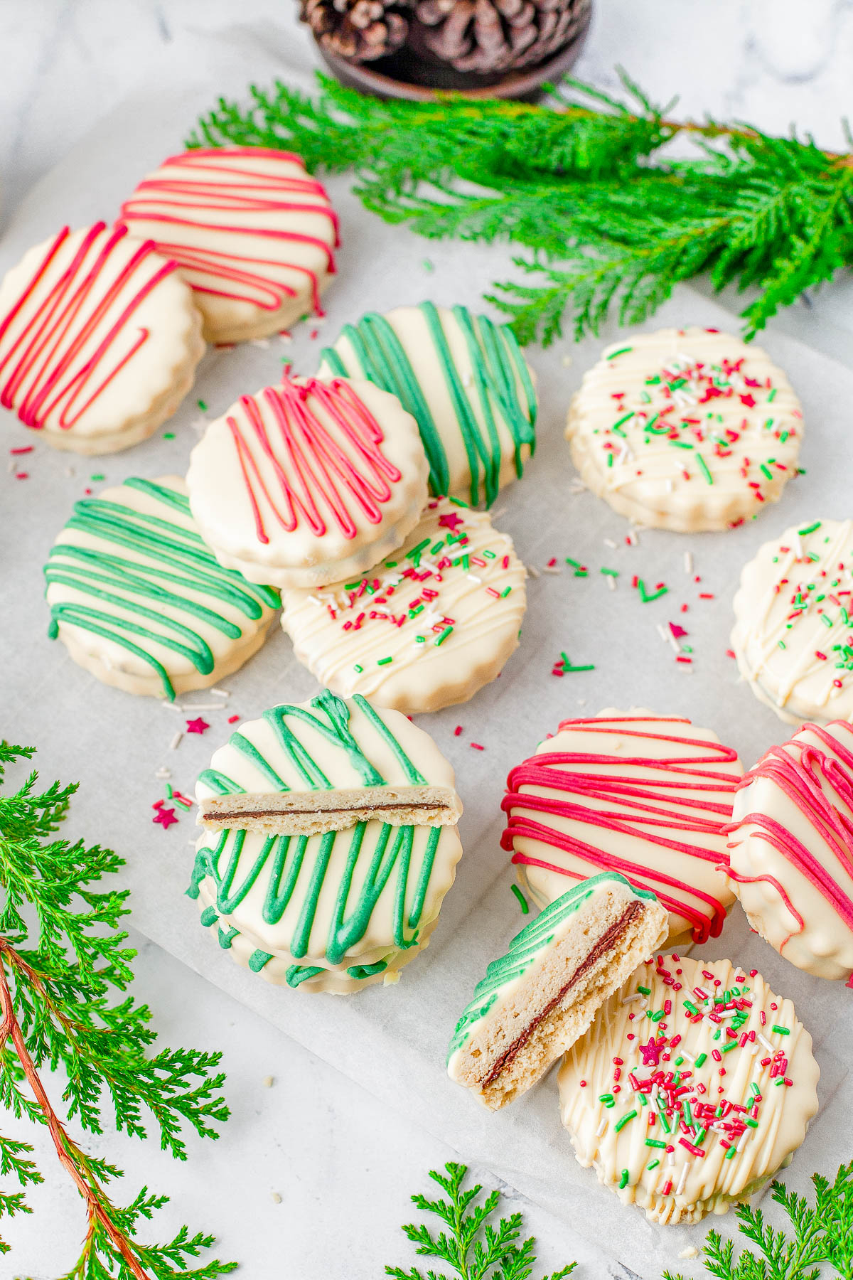 Shortbread Sandwich Cookies - Chocolate filling is sandwiched between two buttery shortbread cookies before the cookies are dipped in sweet white chocolate and festively decorated! EASY enough for novice bakers and PERFECT for holiday entertaining, gifting, and cookie exchanges! 