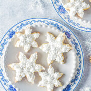 Frosted Snowflake Sugar Cookies - Classic sugar cookies that are heavenly sweet, soft, and all dressed up with piped vanilla frosting and sprinkles! They're always the biggest hit at Christmas parties and cookie exchanges! Easy enough for novice bakers thanks to my straightforward directions which set you up for PERFECT Christmas cookies!