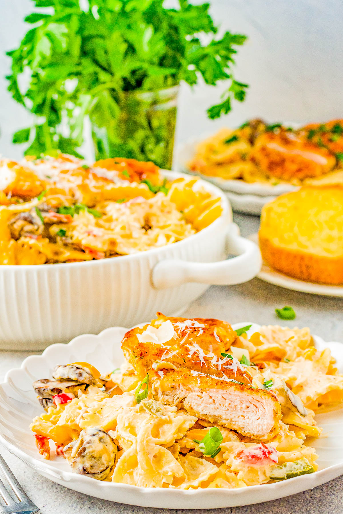 Creamy Cajun Chicken Pasta - Juicy Parmesan-crusted chicken and tender pasta with vegetables are tossed together in a creamy Cajun sauce making this recipe a family FAVORITE! My homemade version is a Chili's Restaurant copycat but I assure you, this is a better-than-the-restaurant dish you'll want to put on rotation even on busy weeknights!