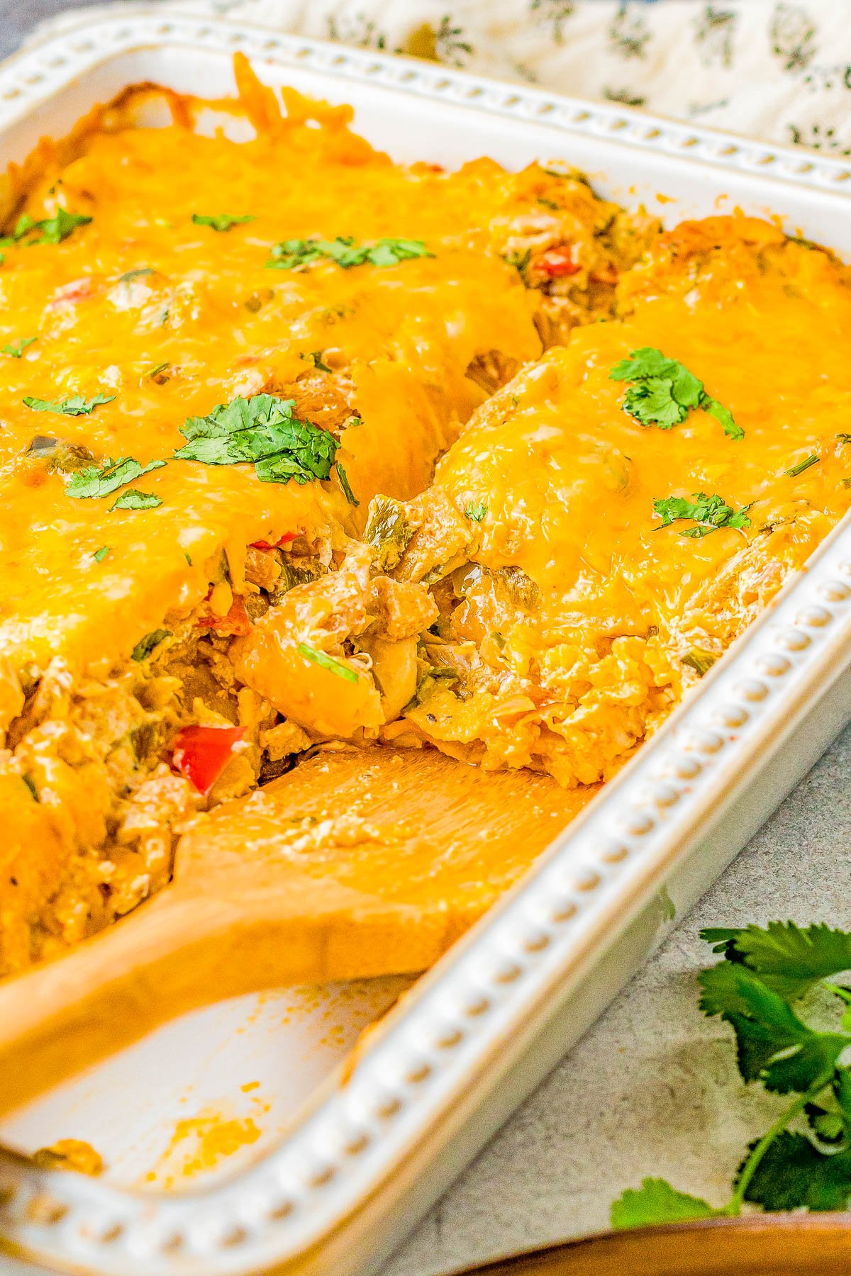 King Ranch Chicken - Nothing says comfort food like an EASY casserole recipe with shredded chicken, cheese, salsa, sour cream, layered with tortillas, and seasoned to perfection! Use rotisserie chicken to save time making this a great family-friendly weeknight dinner recipe!