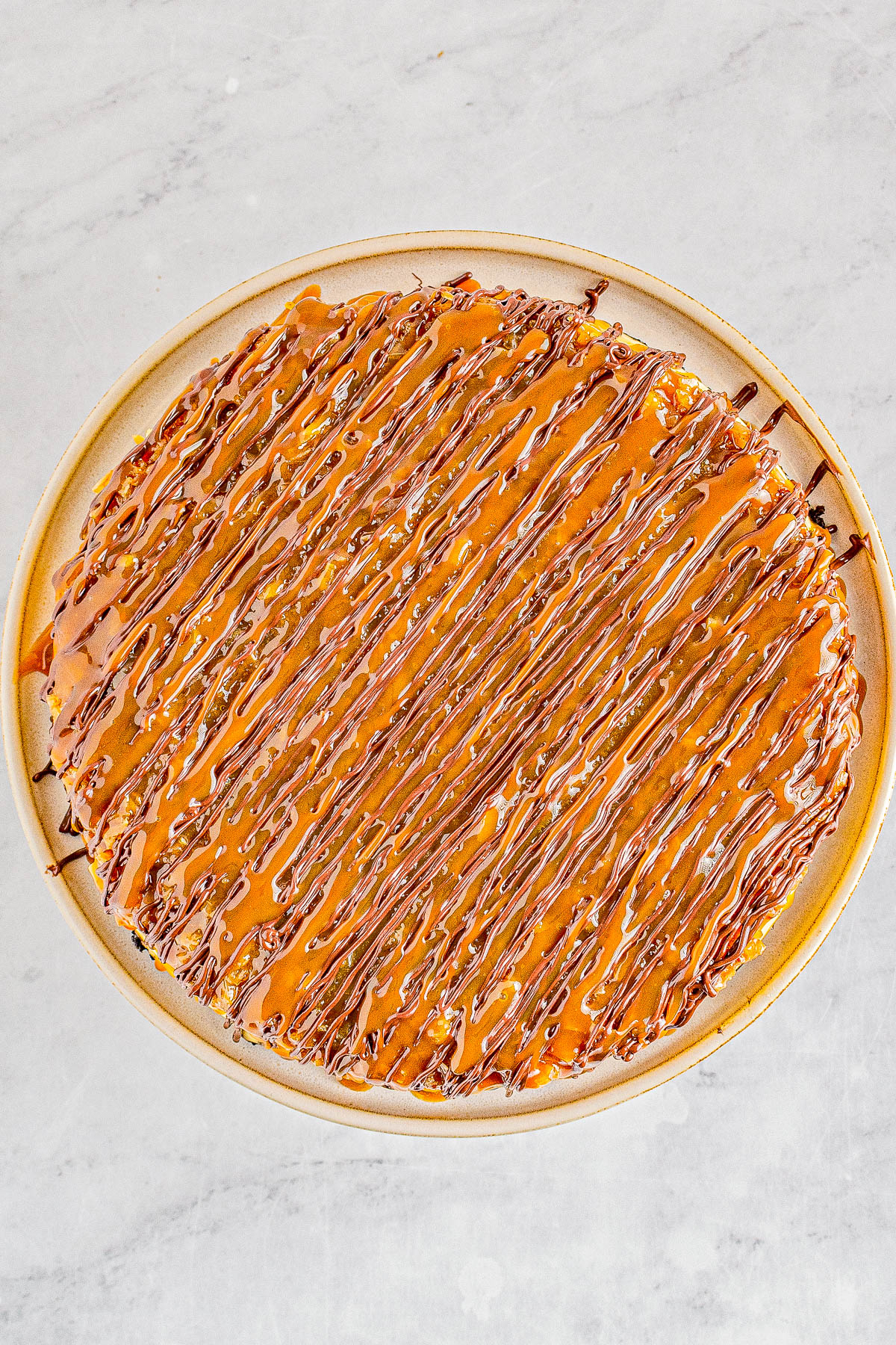 Samoa Cheesecake - Smooth, creamy cheesecake with an Oreo crust and topped with chewy toasted coconut, caramel, and chocolate! If you're a fan of Girl Scout Samoas Cookies, this homemade rich and decadent cheesecake with the same flavors is PURE PERFECTION! Clear and easy directions even if you've never made a cheesecake so yours turns out amazing.