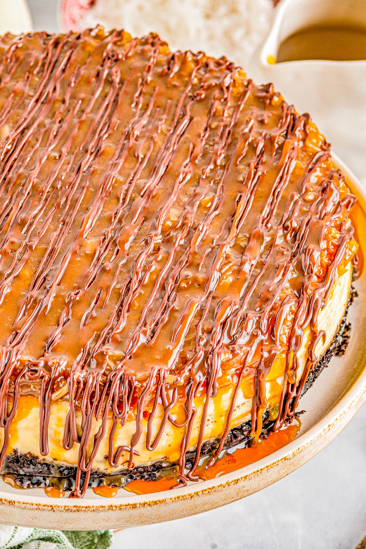 amoa Cheesecake - Smooth, creamy cheesecake with an Oreo crust and topped with chewy toasted coconut, caramel, and chocolate! If you're a fan of Girl Scout Samoas Cookies, this homemade rich and decadent cheesecake with the same flavors is PURE PERFECTION! Clear and easy directions even if you've never made a cheesecake so yours turns out amazing.