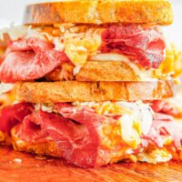 Air Fryer Reuben Sandwiches - Deli-worthy reuben sandwiches at home complete with rye bread, Russian dressing, melted Swiss cheese, and plenty of corned beef! The air fryer helps get the bread extra crispy but stovetop cooking directions are also provided. Get ready because these sandwiches are generously sized and SO GOOD!