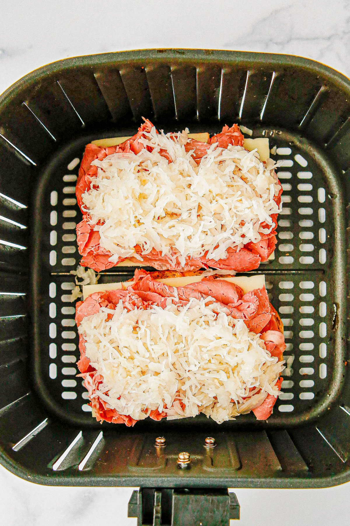 Air Fryer Reuben Sandwiches - Deli-worthy reuben sandwiches at home complete with rye bread, Russian dressing, melted Swiss cheese, and plenty of corned beef! The air fryer helps get the bread extra crispy but stovetop cooking directions are also provided. Get ready because these sandwiches are generously sized and SO GOOD!